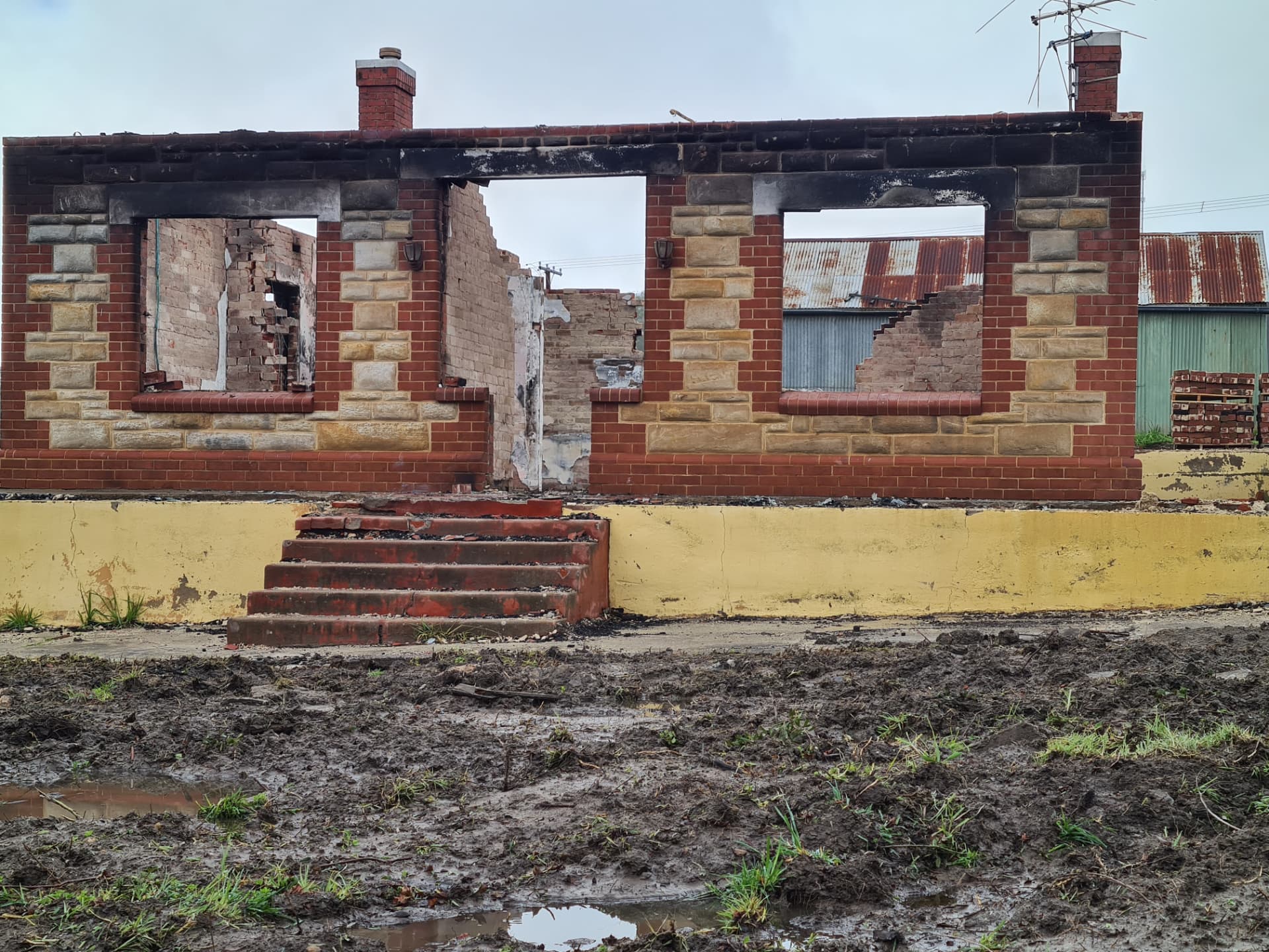 Burnt-out brick facade of a destroyed building with empty window openings